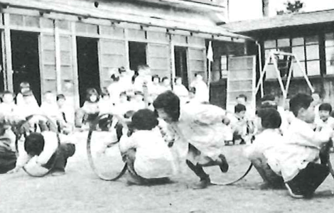 秋の運動会で輪くぐりをする子どもたち